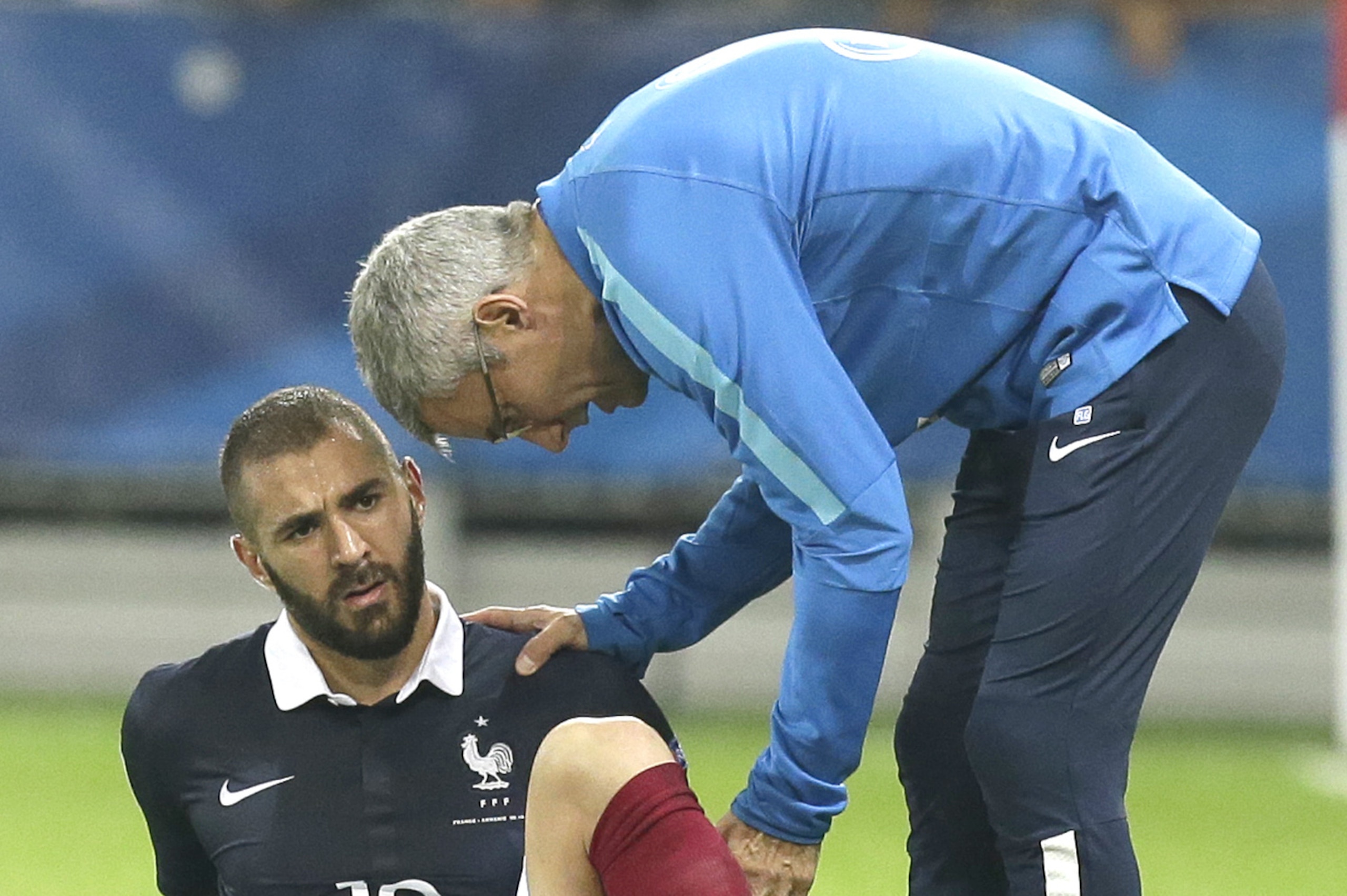 Doctor of France's soccer team, Franck Le Gall, examines Karim Benzema,  as he is injured during the friendly soccer match against Armenia, in the stadium of Nice, southeastern France, Thursday, Oct 8, 2015. Benzema gives up for the next friendly match against Denmark next Sunday. (AP Photo/Lionel Cironneau)