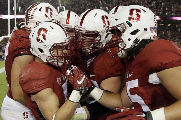Stanford's Christian McCaffrey, left, is mobbed by teammates after his touchdown run against Arizona during the first half of an NCAA college football game Saturday, Oct. 3, 2015, in Stanford, Calif.  (AP Photo/Marcio Jose Sanchez)