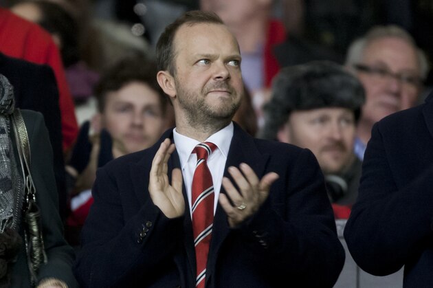 Manchester United chief executive Ed Woodward, centre, applauds before the team's English Premier League soccer match against Tottenham at Old Trafford Stadium, Manchester, England, Wednesday Jan. 1, 2014. (AP Photo/Jon Super)