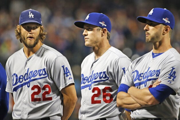 Los Angeles Dodgers pitcher Clayton Kershaw (22) glances at Los Angeles Dodgers' Chase Utley (26) as the crowd boos Utley during baseline introductions for baseball's Game 3 of the National League Division Series against the New York Mets, Monday, Oct. 12, 2015, in New York. Utley was disciplined for sliding hard into New York Mets' Ruben Tejada in Game 2, causing Tejada to break his leg. (AP Photo/Kathy Willens)