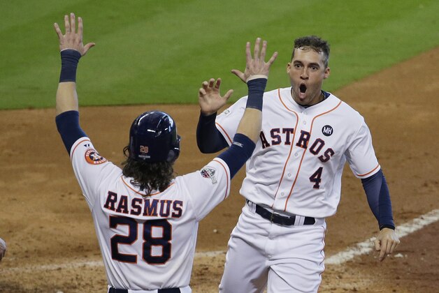 Houston Astros' George Springer (4) is greeted at the plate by Colby Rasmus (28) as he scores on teammate Carlos Correa's hit against the Kansas City Royals in the fifth inning during Game 4 of baseball's American League Division Series, Monday, Oct. 12, 2015, in Houston.  (AP Photo/Patric Schneider)