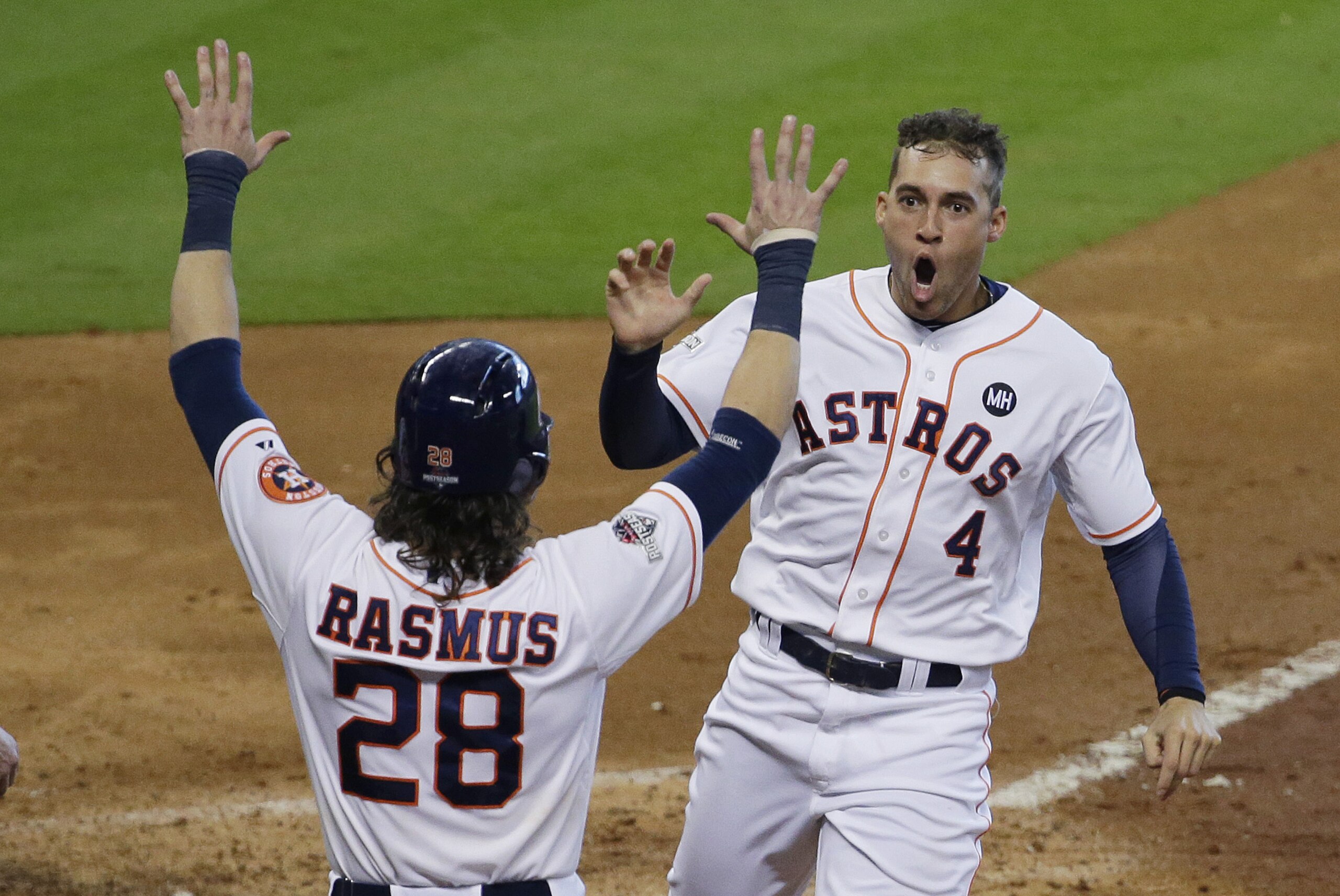 Houston Astros' George Springer (4) is greeted at the plate by Colby Rasmus (28) as he scores on teammate Carlos Correa's hit against the Kansas City Royals in the fifth inning during Game 4 of baseball's American League Division Series, Monday, Oct. 12, 2015, in Houston.  (AP Photo/Patric Schneider)