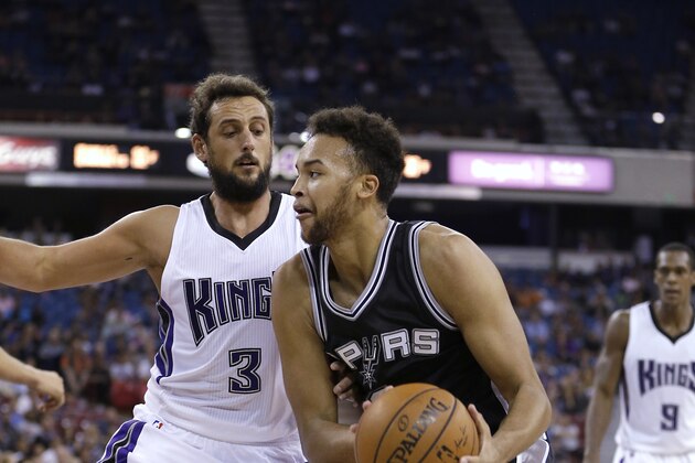 San Antonio Spurs guard Kyle Anderson, right, goes to the basket against Sacramento Kings forward Marco Belinelli during the second half of an NBA preseason basketball game in Sacramento, Calif., Thursday, Oct. 8, 2015. The Kings won 95-92. (AP Photo/Rich Pedroncelli)
