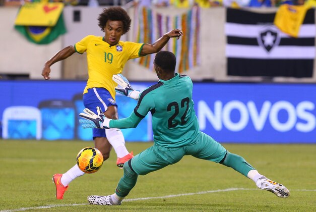 Sep 9, 2014; East Rutherford, NJ, USA; Brazil midfielder Willian (19) scores a goal on Ecuador goalkeeper Alexander Dominguez (22) during the first half at MetLife Stadium. Mandatory Credit: Ed Mulholland-USA TODAY Sports