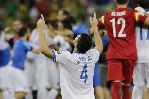 Greece's Kostas Manolas and his teammates celebrate after their 2-1 victory over Ivory Coast during the group C World Cup soccer match between Greece and Ivory Coast at the Arena Castelao in Fortaleza, Brazil, Tuesday, June 24, 2014. (AP Photo/Bernat Armangue)