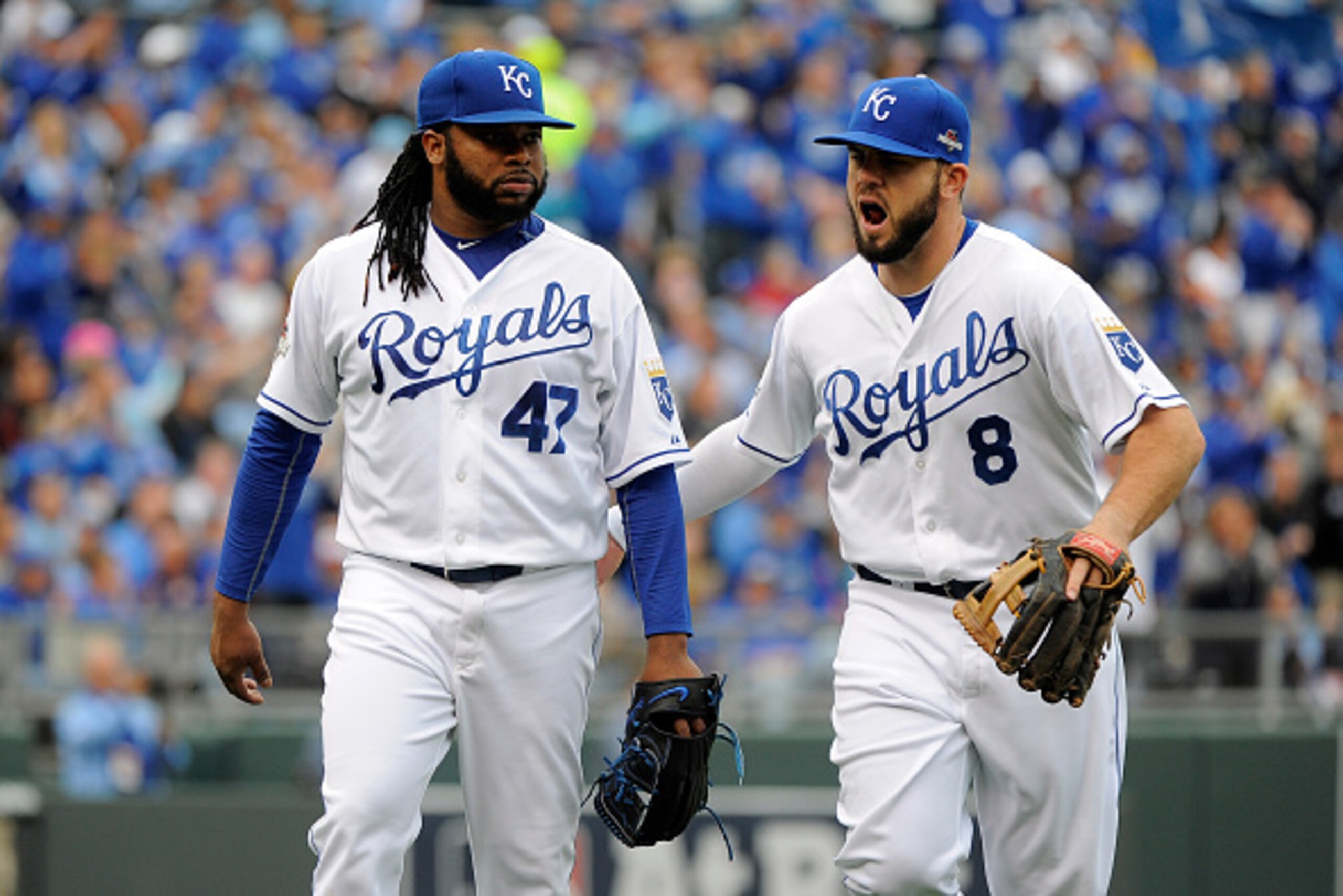 KANSAS CITY, MO - OCTOBER 09:  Mike Moustakas #8 of the Kansas City Royals reacts with Johnny Cueto #47 after closing the fourth inning against the Houston Astros during game two of the American League Division Series at Kauffman Stadium on October 9, 2015 in Kansas City, Missouri.  (Photo by Ed Zurga/Getty Images)