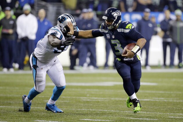 Seattle Seahawks quarterback Russell Wilson (3) runs against Carolina Panthers defensive end Mario Addison (97) during the second half of an NFL divisional playoff football game in Seattle, Saturday, Jan. 10, 2015. (AP Photo/Ted S. Warren)