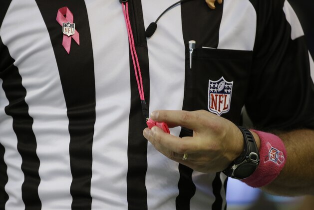 An NFL football official holds a pink whistle used for breast cancer awareness during an NFL football game between the Seattle Seahawks and the Detroit Lions, Monday, Oct. 5, 2015, in Seattle. (AP Photo/Elaine Thompson)
