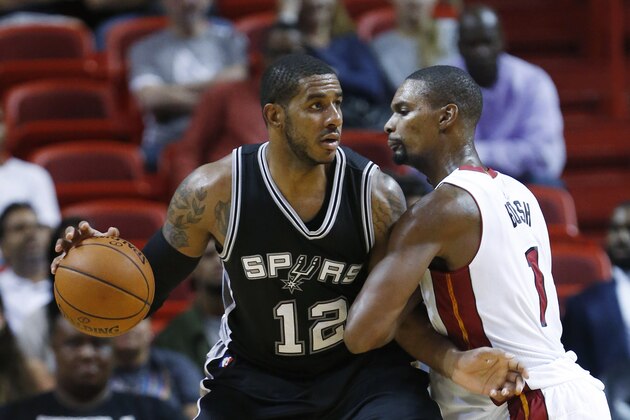 San Antonio Spurs forward LaMarcus Aldridge (12) drives up against Miami Heat forward Chris Bosh (1) during the second half of a preseason NBA basketball game, Monday, Oct. 12, 2015, in Miami. The Heat defeated the Spurs 97-94. (AP Photo/Wilfredo Lee)