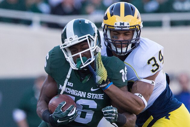 EAST LANSING, MI - OCTOBER 25: Donavon Clark #76 of the Michigan State Spartans makes the catch and runs for a short gain as Jeremy Clark #34 of the Michigan Wolverines makes the stop during the second quarter of the game at Spartan Stadium on October 25 , 2014 in East Lansing, Michigan. (Photo by Leon Halip/Getty Images)