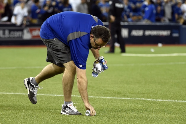 Oct 14, 2015; Toronto, Ontario, CAN; Grounds crew workers pick up trash from the field after Texas Rangers second baseman Rougned Odor (not pictured) is ruled to have scored a run in the 7th inning against the Toronto Blue Jays in game five of the ALDS at Rogers Centre. Mandatory Credit: Peter Llewellyn-USA TODAY Sports