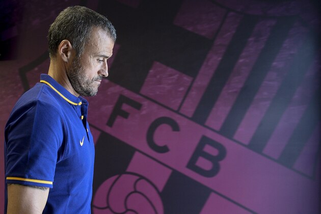 Barcelona's coach Luis Enrique walks past his team's badge as he leaves after giving a press conference following a training session at the Sports Center FC Barcelona Joan Gamper in Sant Joan Despi, near Barcelona on July 14, 2015.  AFP PHOTO / JOSEP LAGO        (Photo credit should read JOSEP LAGO/AFP/Getty Images)