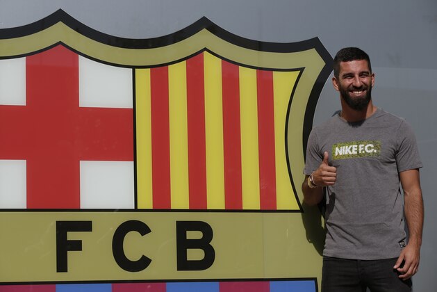 Barcelona's new signing Arda Turan gestures during  at the club's office at the Camp Nou stadium in Barcelona, Spain, Thursday, July 9, 2015. The European champions announced a five-year deal for the 28-year-old Turkey midfielder. Barcelona made the signing despite currently being without a permanent president or executive board members, who resigned under club bylaws before elections on July 18. (AP Photo/Manu Fernandez)