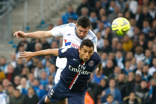 Marseille's French forward Andre-Pierre Gignac, top, scores over the top of Paris Saint Germain's Brazilian defender Marquinhos during the League One soccer match between Marseille and Paris Saint-Germain, at the Velodrome Stadium, in Marseille, southern France, Sunday, April 5, 2015. (AP Photo/Claude Paris)