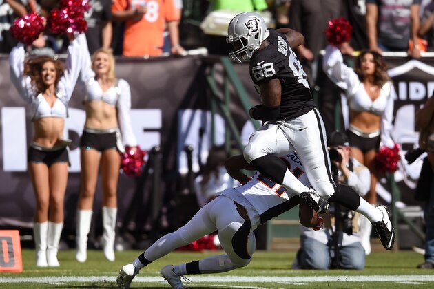 OAKLAND, CA - OCTOBER 11:  Clive Walford #88 of the Oakland Raiders leaps over would be tackler Aqib Talib #21 of the Denver Broncos during the second quarter at the O.co Coliseum on October 11, 2015 in Oakland, California.  (Photo by Thearon W. Henderson/Getty Images)