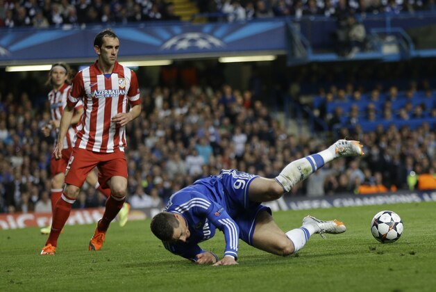 Chelsea's Fernando Torres, right falls in front of Atletico's Diego Godin during the Champions League semifinal second leg soccer match between Chelsea and Atletico Madrid at Stamford Bridge Stadium in London Wednesday, April 30, 2014. (AP Photo/Kirsty Wigglesworth)