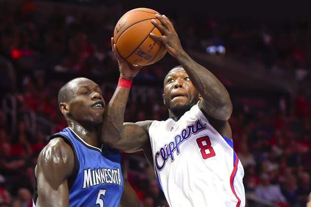 Los Angeles Clippers guard Nate Robinson (8) drives past Minnesota Timberwolves center Gorgui Dieng (5), of Senegal, during the first half of an NBA basketball game Monday, March 9, 2015, in Los Angeles. (AP Photo/Gus Ruelas)