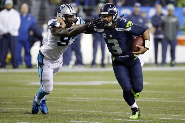 Seattle Seahawks quarterback Russell Wilson (3) runs against Carolina Panthers defensive end Mario Addison (97) during the second half of an NFL divisional playoff football game in Seattle, Saturday, Jan. 10, 2015. (AP Photo/Ted S. Warren)