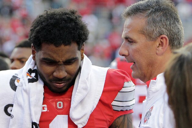 FILE - In this Saturday, Sept. 12, 2015, file photo, Ohio State receiver Braxton Miller, left, talks with head coach Urban Meyer after their NCAA college football game against Hawaii in Columbus, Ohio. Meyer devised an offense in which some receivers are not just receivers. The position is called H-back as in hybrid and it has been a great way to get that player who is not quite a tailback and not quite a wide receiver lots of touches and plenty of room to operate.  Miller could not be in better hands as he makes the conversion from quarterback to receiver.(AP Photo/Jay LaPrete, File)