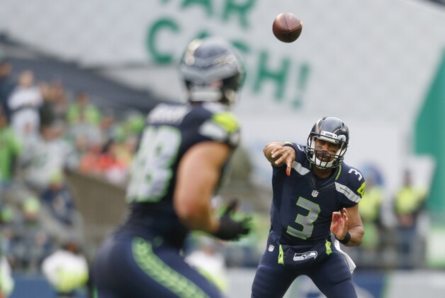 Seattle Seahawks quarterback Russell Wilson completes a pass to tight end Jimmy Graham during the first half of a preseason NFL football game against the Denver Broncos, Friday, Aug. 14, 2015, in Seattle. (AP Photo/John Froschauer)