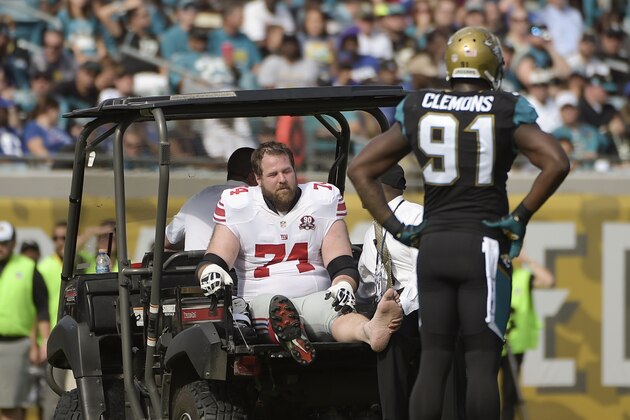 Jacksonville Jaguars defensive end Chris Clemons (91) watches as New York Giants tackle Geoff Schwartz (74) leave the field after he was injured during the first half of an NFL football game in Jacksonville, Fla., Sunday, Nov. 30, 2014. (AP Photo/Phelan M. Ebenhack)