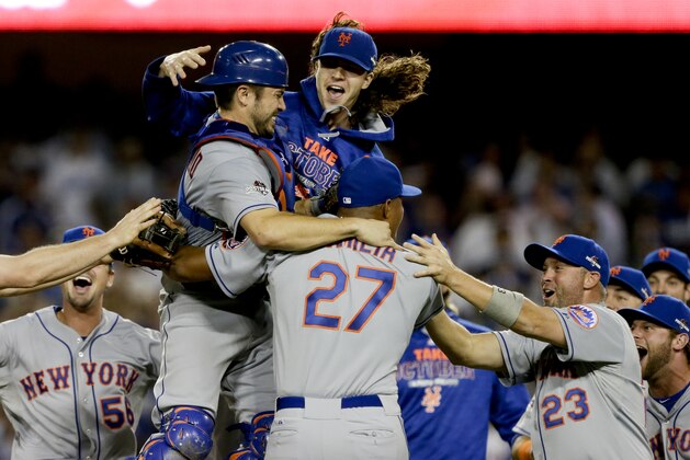 New York Mets starting pitcher Jacob deGrom, above right, catcher Travis d'Arnaud, left, and other Mets players celebrate a 3-2 win over the Los Angeles Dodgers in Game 5 of baseball's National League Division Series on Thursday, Oct. 15, 2015, in Los Angeles. (AP Photo/Alex Gallardo)