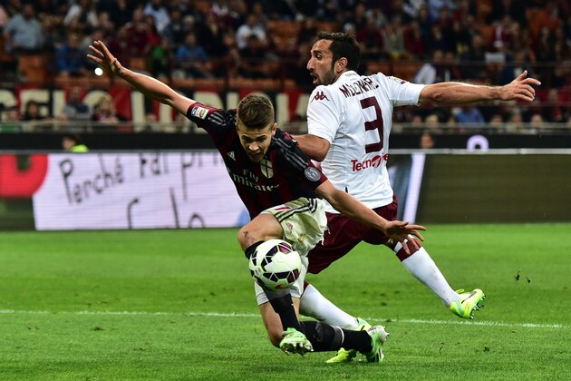 AC Milan's midfielder from Netherlands Marco Van Ginkel   (L) is tackled by Torino's defender Cristian Molinaro during the Serie A football match between AC Milan and  Torino at San Siro Stadium in Milan on May 24, 2015. AFP PHOTO / GIUSEPPE CACACE        (Photo credit should read GIUSEPPE CACACE/AFP/Getty Images)