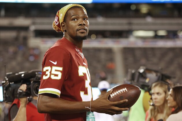 Oklahoma City Thunder forward Kevin Durant stands on the sidelines before an NFL football game between the New York Giants and the Washington Redskins Thursday, Sept. 24, 2015, in East Rutherford, N.J. (AP Photo/Kathy Willens)