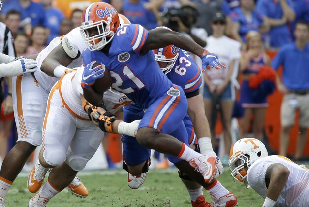 FILE - In this Sept. 26, 2015, file photo, Florida running back Kelvin Taylor (21) runs against Tennessee during the first half of an NCAA college football game in Gainesville, Fla. Kelvin Taylor was publicly ripped and then benched following a throat-slash gesture last month. He bounced back to become a leader and offensive workhorse for the 25th-ranked Gators. (AP Photo/John Raoux, File)