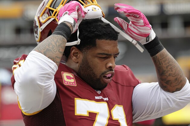Washington Redskins tackle Trent Williams (71) pulls off his helmet during the first half of an NFL football game against the Philadelphia Eagles in Landover, Md., Sunday, Oct. 4, 2015. Williams is using a pink mouthguard in support of the NFL's breast cancer awareness month. (AP Photo/Mark Tenally)