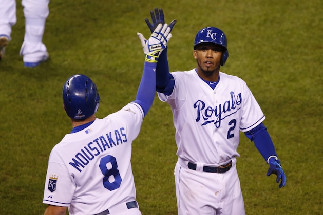 Kansas City Royals' Alcides Escobar, right, celebrates with Mike Moustakas after scoring on a double by Eric Hosmer during the eighth inning in Game 1 of baseball's American League Championship Series against the Toronto Blue Jays on Friday, Oct. 16, 2015, in Kansas City, Mo. (AP Photo/Paul Sancya)