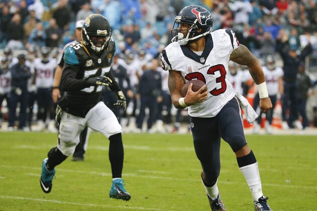 Houston Texans running back Arian Foster (23) runs past Jacksonville Jaguars outside linebacker Geno Hayes (55) for a 1-yard touchdown during the second half of an NFL football game in Jacksonville, Fla., Sunday, Dec. 7, 2014. (AP Photo/Stephen B. Morton)