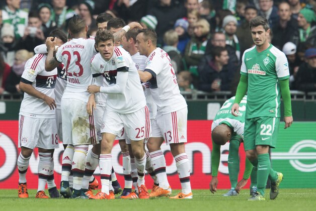 Players of Bayern Muenchen react after Bayern's Thomas Mueller, center, scored the opening goal for his team during the German Bundesliga soccer match between Werder Bremen and FC Bayern Muenchen in Bremen, Germany, Saturday, Oct. 17, 2015.  At right Bremen's Fin Bartels. (AP Photo/Joerg Sarbach)