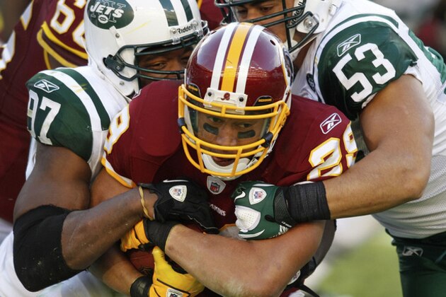 Washington Redskins running back Roy Helu, center, is tackled by New York Jets linebackers Calvin Pace, left and Josh Mauga, right, during the second half of an NFL football game in Landover, Md., Sunday, Dec. 4, 2011. (AP Photo/Evan Vucci)