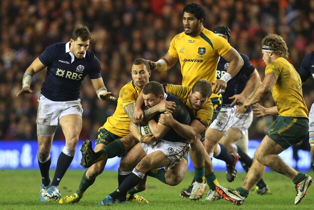 Scotland's Duncan Weir, center, is tackled by Australia's Quade Cooper, left, and  James Slipper, right, during the international rugby match at Murrayfield, Edinburgh, Scotland, Saturday Nov. 23, 2013. (AP Photo/Scott Heppell)