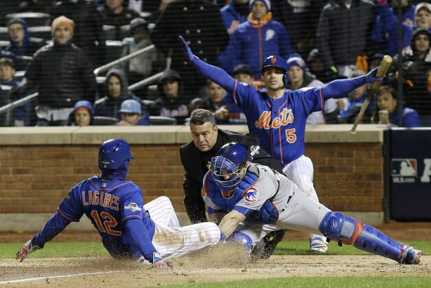 New York Mets' Juan Lagares slides safely under the tag of Chicago Cubs catcher Miguel Montero during the seventh inning of Game 1 of the National League baseball championship series Saturday, Oct. 17, 2015, in New York. Lagares scored from third on a sacrifice fly by Curtis Granderson. (AP Photo/David J. Phillip)