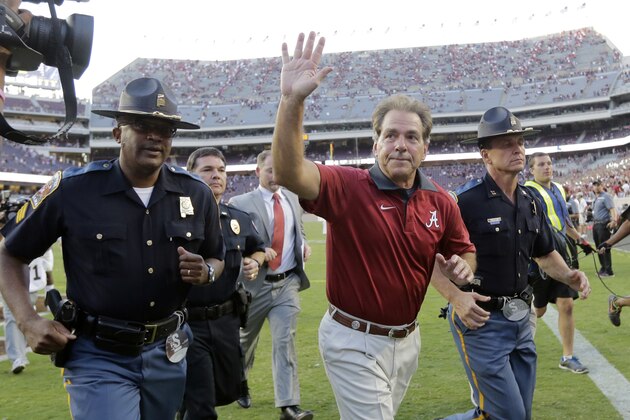 Alabama head coach Nick Saban, center, waves to fans as he runs off the field following an NCAA college football game, Saturday, Oct. 17, 2015, in College Station, Texas. Alabama won 41-23. (AP Photo/Eric Gay)