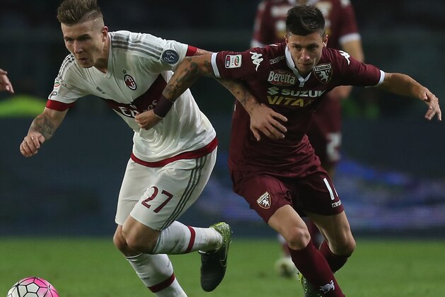 AC Milan's defender Pablo Estifer Armero of Colombia (L) fights for the ball with Torino's midfielder Daniele Baselli from Italy during the Italian Serie A football match Torino Vs AC Milan on October 17, 2015 at the 'Olympic Stadium' in Turin.  AFP PHOTO / MARCO BERTORELLO        (Photo credit should read MARCO BERTORELLO/AFP/Getty Images)