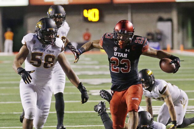 Utah running back Devontae Booker (23) carries the ball as Arizona State linebacker Salamo Fiso (58) looks on in the first half during an NCAA college football game Saturday, Oct. 17, 2015, in Salt Lake City. (AP Photo/Rick Bowmer)