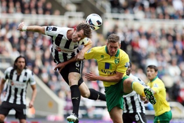 Newcastle United's Mike Williamson, left, vies for the ball with Norwich City's Steve Morison during their English Premier League soccer match at the Sports Direct Arena, Newcastle, England, Sunday, Sept. 23, 2012. (AP Photo/Scott Heppell)