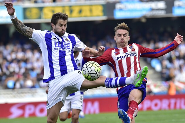 Atletico de Madrid's Antoine Griezmann, right,  duels for the ball with Real Sociedad's Inigo Martinez, during their Spanish La Liga soccer match, at Anoeta stadium in San Sebastian, northern Spain, Sunday, Oct. 18, 2015. (AP Photo/Alvaro Barrientos)