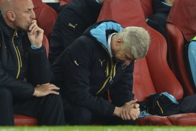 Arsenal's French manager Arsene Wenger (R) and assistant manager Steve Bould (L) reacts as they watch the action from the dug out during the UEFA Champions League Group F football match between Arsenal and Olympiakos at The Emirates Stadium in north London on September 29, 2015. AFP PHOTO / GLYN KIRK        (Photo credit should read GLYN KIRK/AFP/Getty Images)