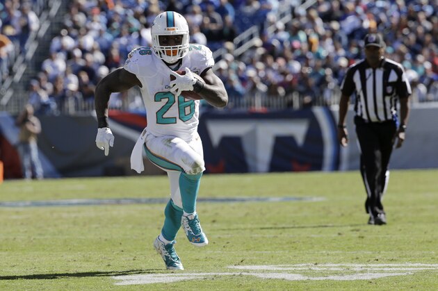 Miami Dolphins running back Lamar Miller runs the ball against the Tennessee Titans in the first half of an NFL football game Sunday, Oct. 18, 2015, in Nashville, Tenn. (AP Photo/James Kenney)