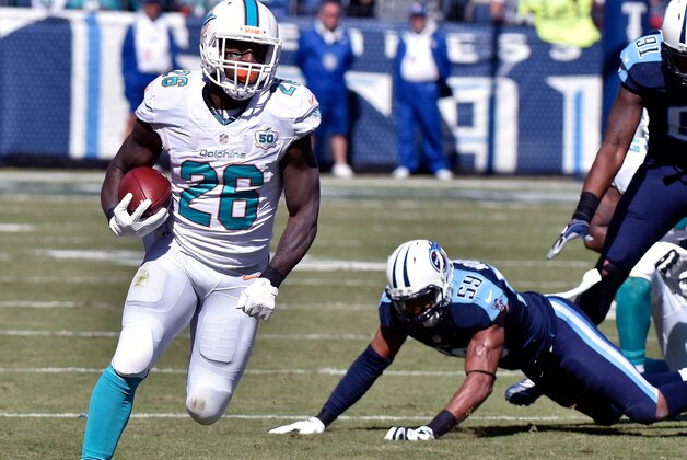 NASHVILLE, TN - OCTOBER 18:  Lamar Miller #26 of the Miami Dolphins rushes against the Tennessee Titans during the first half of a game at Nissan Stadium on October 18, 2015 in Nashville, Tennessee.  (Photo by Frederick Breedon/Getty Images)