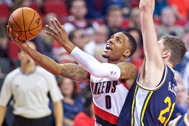 Portland Trail Blazers guard Damian Lillard, left, shoots over Utah Jazz center Tibor Pleiss during the first half of an NBA preseason basketball game in Portland, Ore., Sunday, Oct. 18, 2015. (AP Photo/Craig Mitchelldyer)