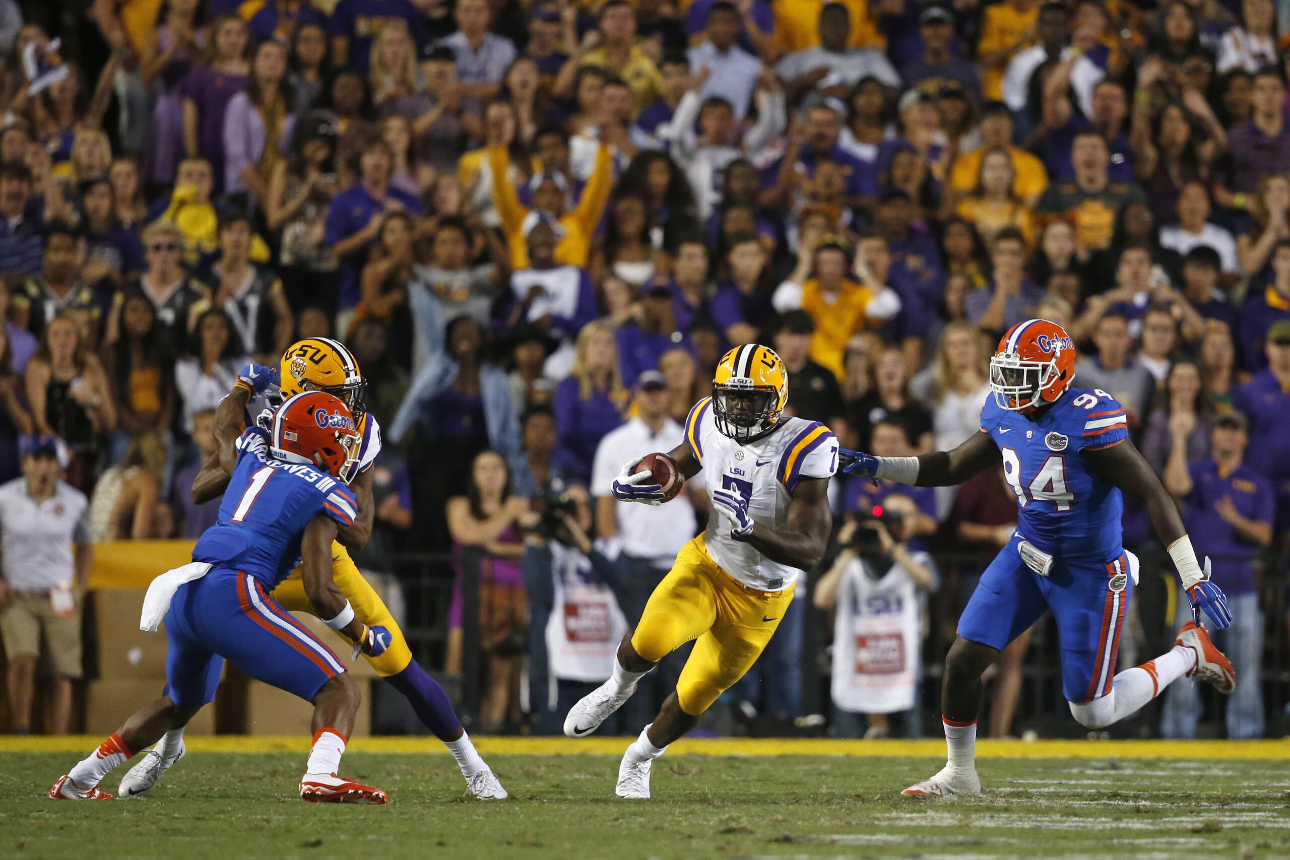 LSU running back Leonard Fournette (7) carries between Florida defensive back Vernon Hargreaves III (1) and defensive lineman Bryan Cox Jr. (94) in the first half of an NCAA college football game in Baton Rouge, La., Saturday, Oct. 17, 2015. (AP Photo/Gerald Herbert)