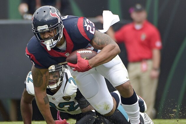 Houston Texans running back Arian Foster (23) tries to keep to his feet as he runs past Jacksonville Jaguars cornerback Aaron Colvin, left, during the first half of an NFL football game in Jacksonville, Fla., Sunday, Oct. 18, 2015. (AP Photo/Phelan M. Ebenhack)