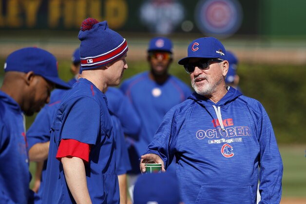 Chicago Cubs manager Joe Maddon, right, talks to Chris Coghlan during a team workout in preparation for Tuesday's Game 3 in baseball's National League Championship Series against the New York Mets, Monday, Oct. 19, 2015, in Chicago. (AP Photo/Charles Rex Arbogast)