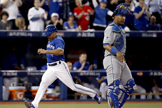 Toronto Blue Jays' Ben Revere scores past Kansas City Royals catcher Salvador Perez on a single by Jose Bautista during the eighth inning in Game 3 of baseball's American League Championship Series on Monday, Oct. 19, 2015, in Toronto. (AP Photo/Matt Slocum)