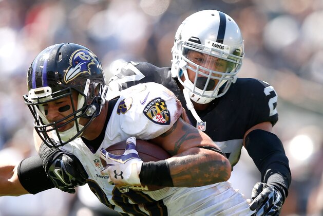 OAKLAND, CA - SEPTEMBER 20:  Crockett Gillmore #80 of the Baltimore Ravens carries for a touchdown against the block of Taylor Mays #27 of the Oakland Raiders in the second quarter against the Oakland Raiders at Oakland-Alameda County Coliseum on September 20, 2015 in Oakland, California.  (Photo by Ezra Shaw/Getty Images)